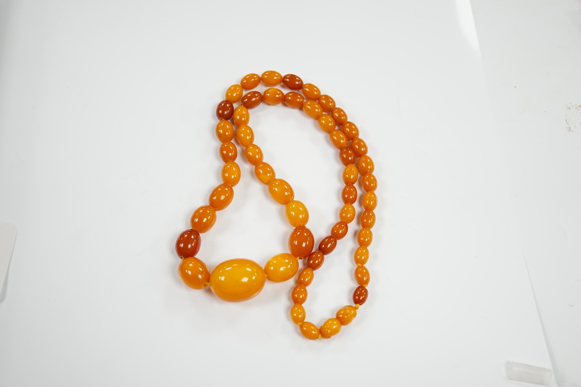 A single strand graduated oval amber bead necklace, 66cm, gross weight 48 grams. Condition - poor to fair